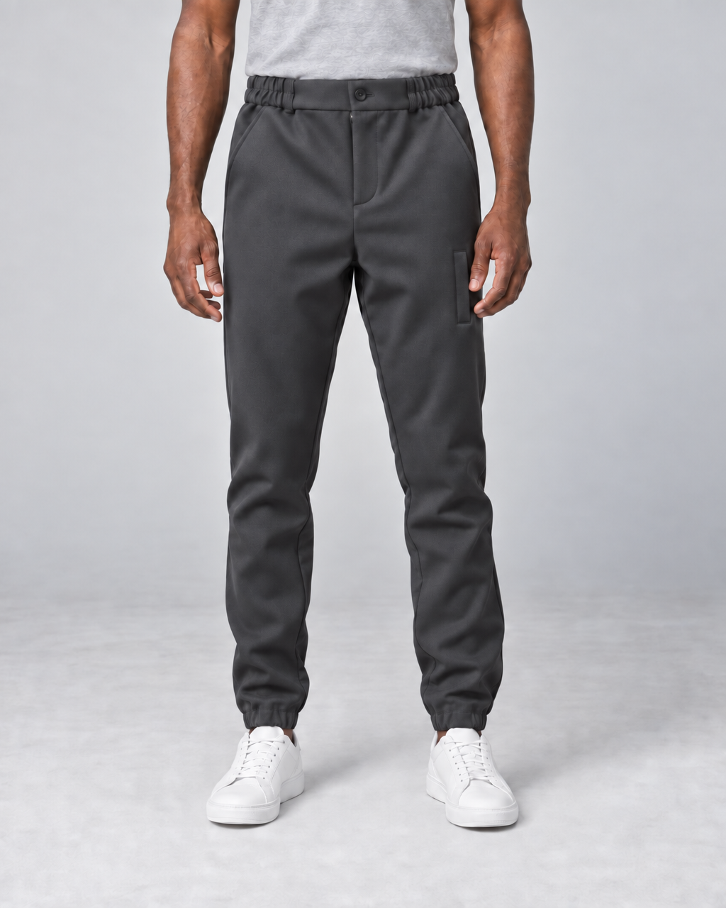 Pantalon gris foncé pour homme, vue de face, avec taille et chevilles élastiquées et poches latérales