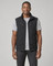 Homme portant un gilet sans manches noir ouvert, vue de face, avec col montant et poches zippées.