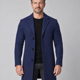 Manteau bleu marine à trois boutons, porté ouvert sur un pull noir, vue de face cadrée à mi-cuisses.