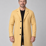 Vue de face recadrée d’un homme portant un manteau jaune moutarde à revers, trois boutons et poches latérales.