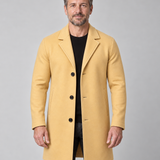 Vue de face recadrée d’un homme portant un manteau jaune moutarde à revers, trois boutons et poches latérales.