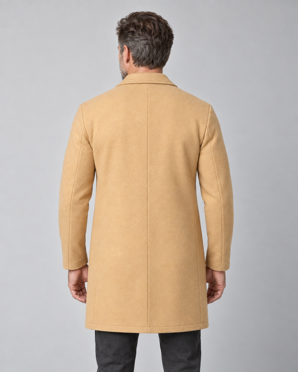 Homme portant un manteau beige clair, cadrage de dos jusqu’aux cuisses