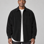 Veste-chemise noire à fines côtes, boutonnée, avec poche poitrine, vue de face cadrée à mi-cuisses.