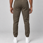 Vue arrière d’un pantalon marron à taille et chevilles élastiquées, porté avec des baskets blanches.