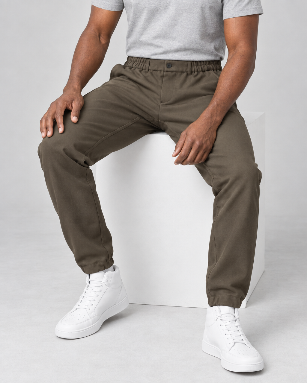 Pantalon marron pour homme à taille et chevilles élastiquées, vu de face sur un modèle assis.
