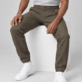 Pantalon marron pour homme à taille et chevilles élastiquées, vu de face sur un modèle assis.