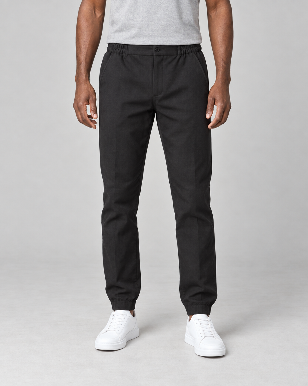Pantalon noir à taille et chevilles élastiquées, vue de face cadrée sur le bas du corps