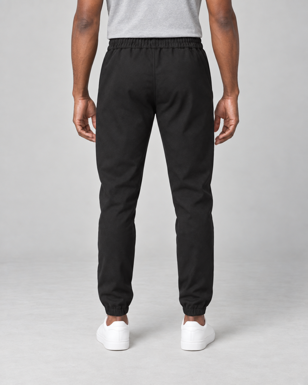 Vue arrière illustrative d’un pantalon noir porté, avec taille et chevilles élastiquées.