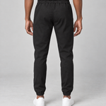 Vue arrière illustrative d’un pantalon noir porté, avec taille et chevilles élastiquées.