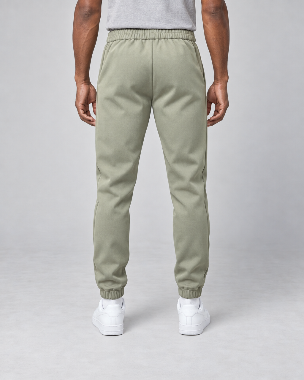 Vue arrière d’un pantalon vert clair à taille et chevilles élastiquées, porté par un mannequin.