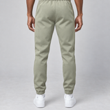 Vue arrière d’un pantalon vert clair à taille et chevilles élastiquées, porté par un mannequin.