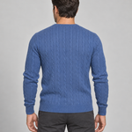 Homme vu de dos portant un pull bleu à torsades, avec manches longues et finitions côtelées.