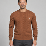 Homme portant un pull marron à col rond et torsades, avec un petit motif blanc sur la poitrine, vue de face.