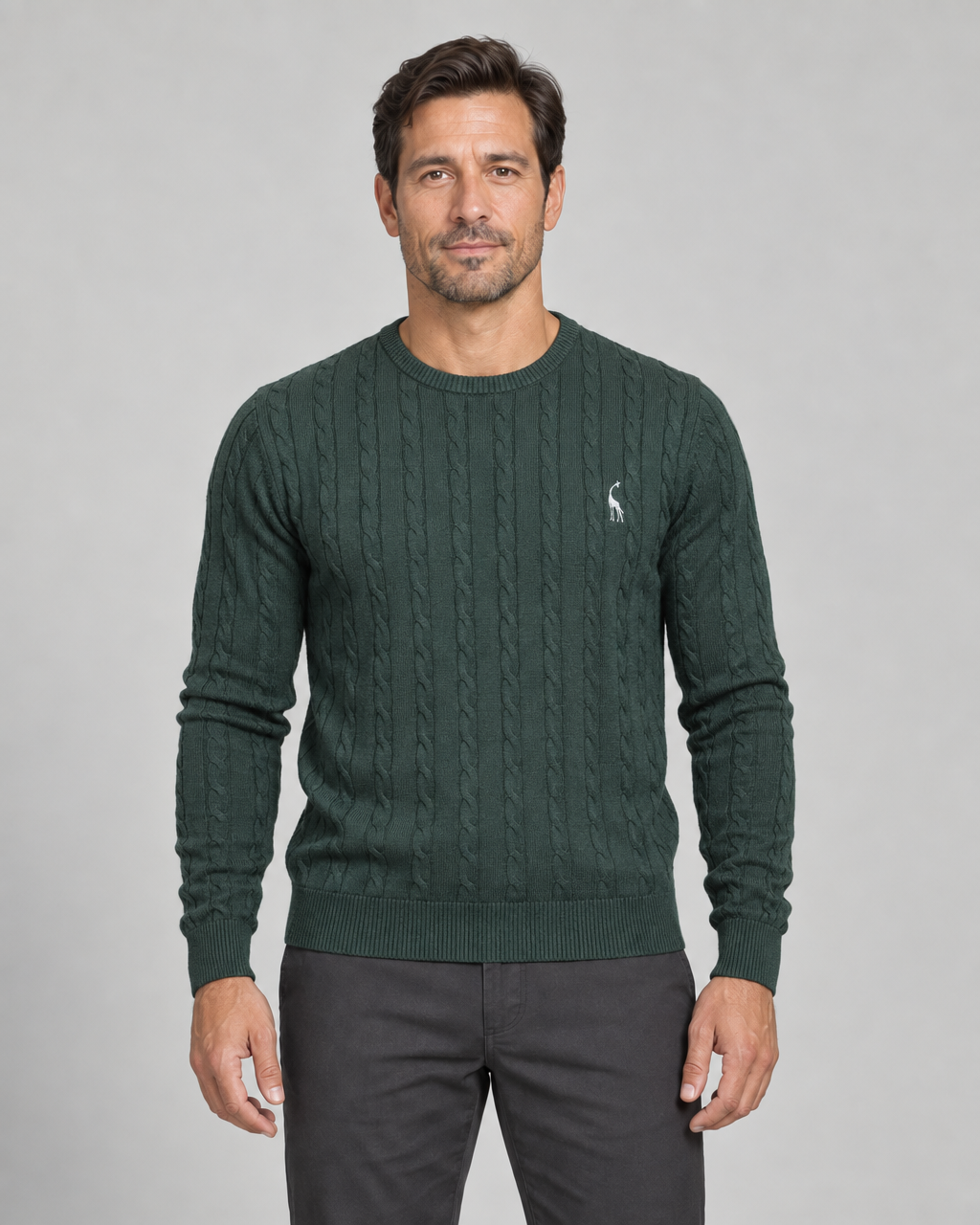 Homme de face portant un pull vert foncé à col rond et motif torsadé, vue cadrée de face.