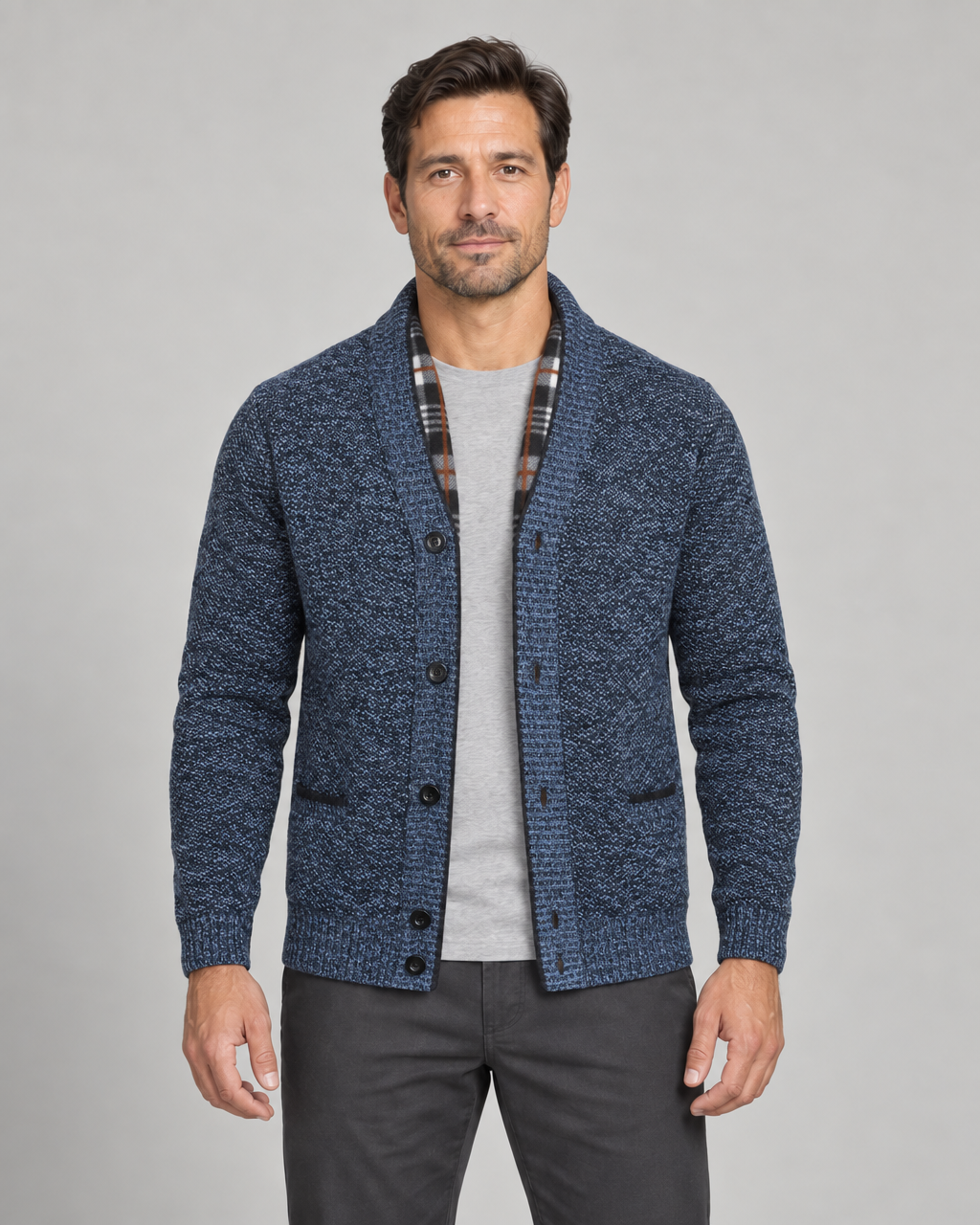Vue de face recadrée d’un homme portant un cardigan bleu chiné à col châle, boutons noirs et poches.