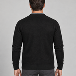 Homme de dos portant un cardigan noir à manches longues, cadré de la tête aux cuisses.