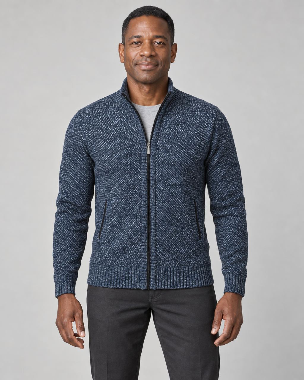 Vue de face d’un homme portant un gilet bleu chiné zippé, à col montant et deux poches latérales.