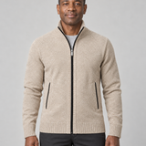 Homme portant un gilet zippé beige à col montant, vue de face cadrée à mi-cuisses.