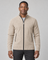 Homme portant un gilet zippé beige à col montant, vue de face cadrée à mi-cuisses.