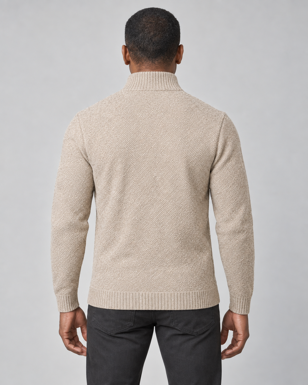 Vue de dos recadrée d’un homme portant un pull beige texturé à col montant et manches longues.