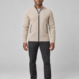 Homme de face en pied portant un gilet zippé beige à col montant et un pantalon noir.