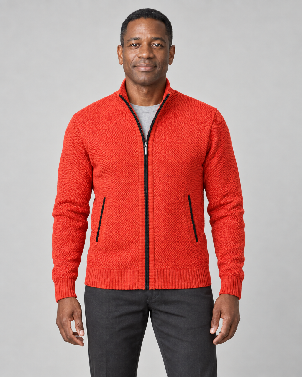 Homme portant un gilet zippé orange à col montant et deux poches, vue de face cadrée à mi-cuisses