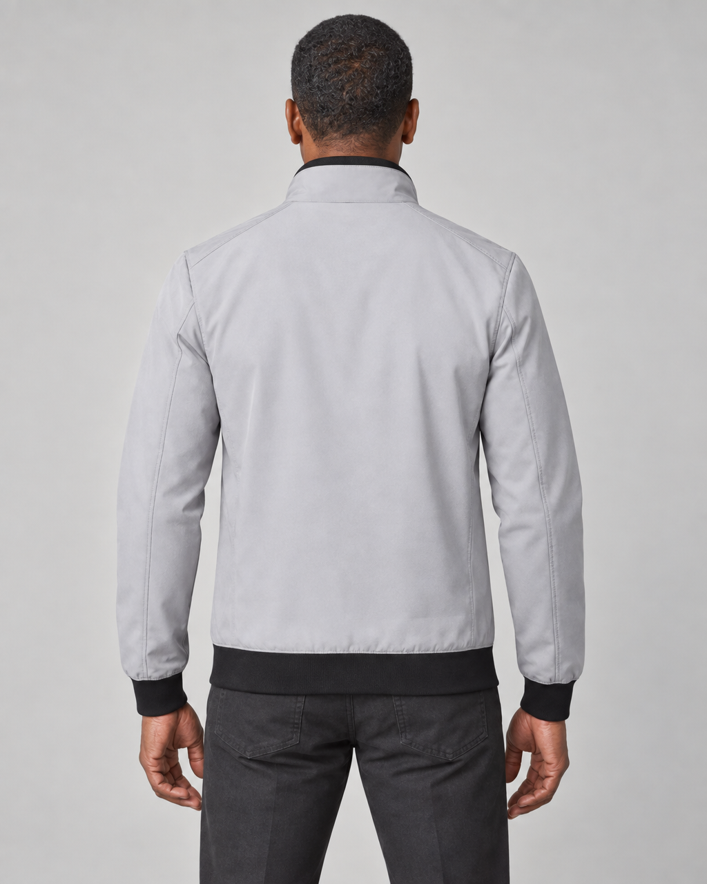 Homme de dos portant une veste grise courte à col montant, avec poignets et taille noirs