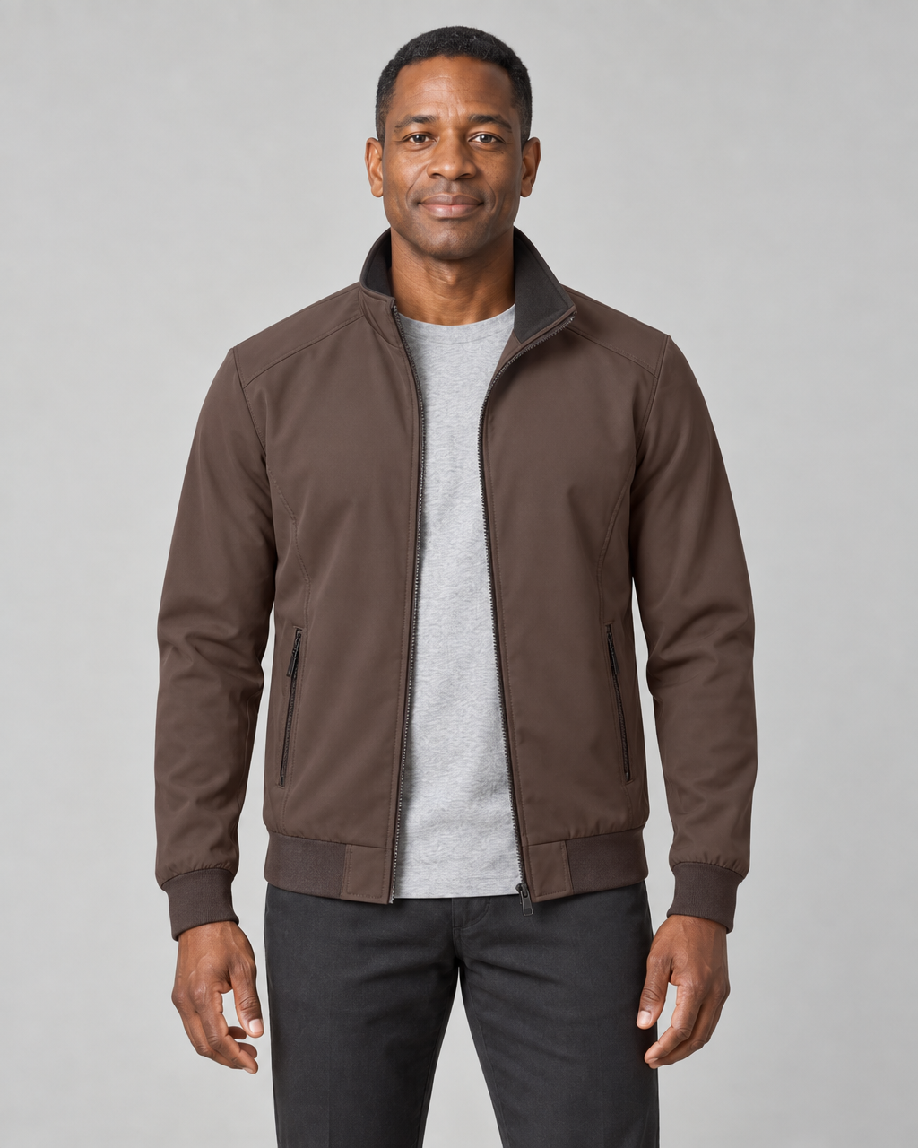 Veste marron portée ouverte, avec col montant et poches zippées, vue de face cadrée à mi-cuisses