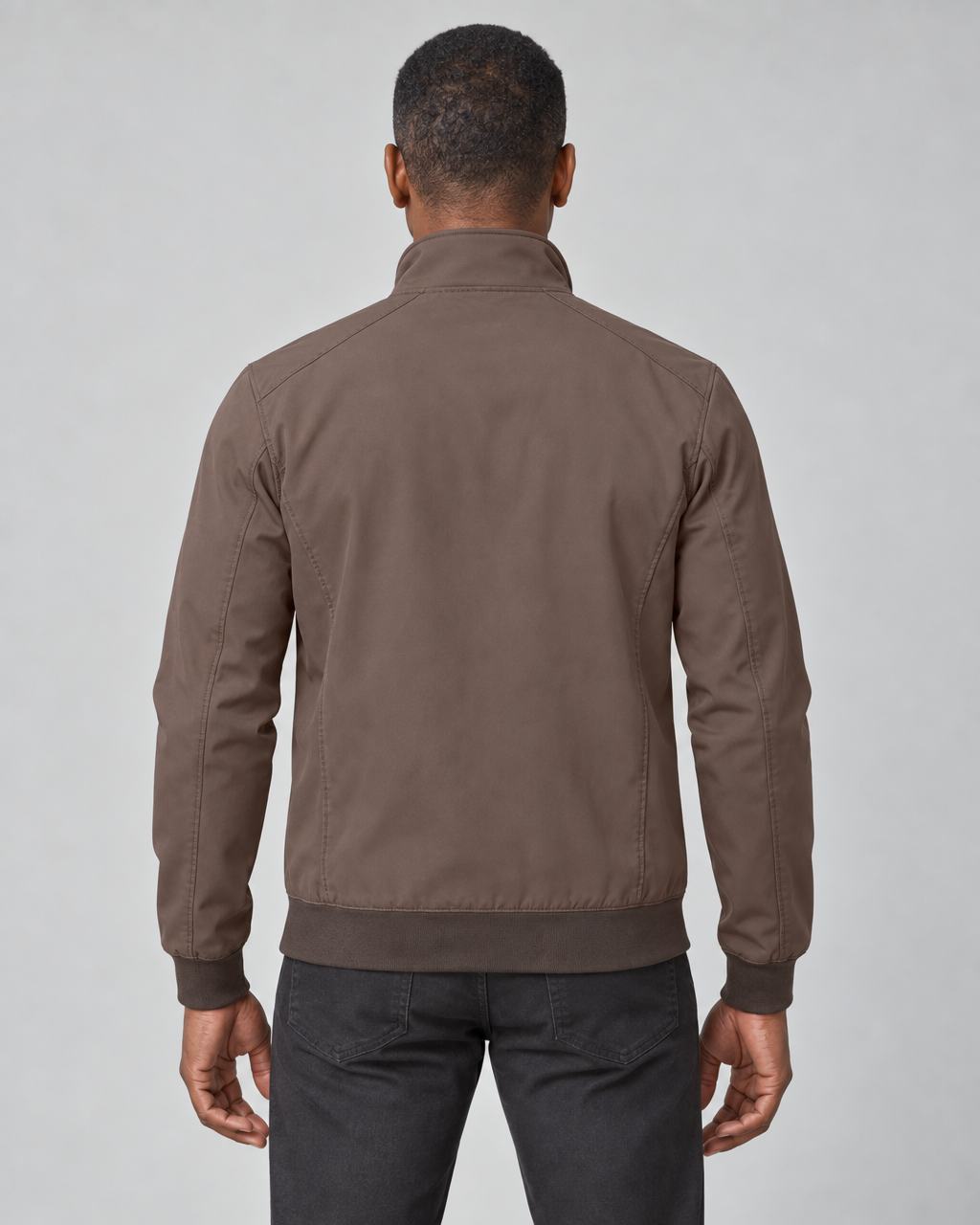 Homme de dos portant une veste marron à col montant, poignets et taille côtelés.