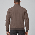 Homme de dos portant une veste marron à col montant, poignets et taille côtelés.