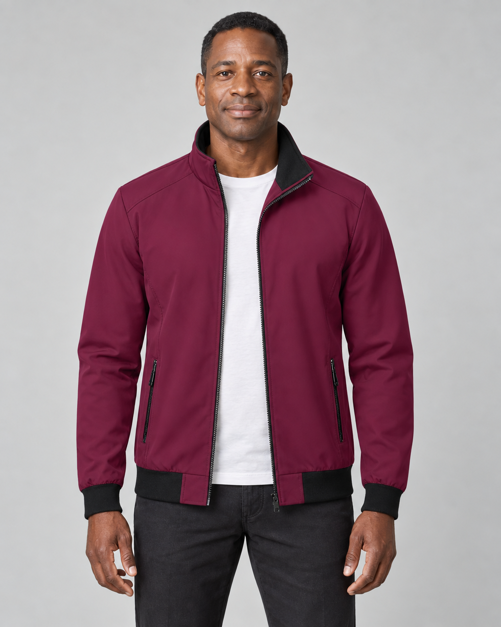 Homme portant une veste rouge foncé ouverte, vue de face cadrée, avec col montant et poches zippées