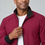 Vue rapprochée de face d’une veste rouge, ouverte, avec col et poignets noirs et poches zippées.