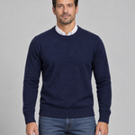 Homme portant un pull bleu marine à col rond, manches longues, vu de face et cadré à mi-cuisses