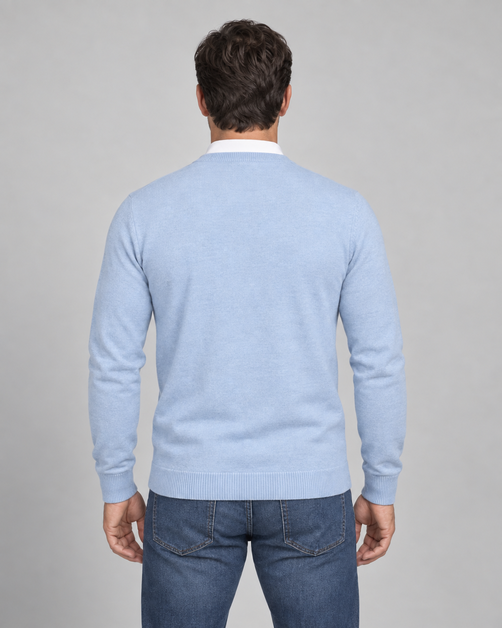 Homme de dos portant un pull bleu clair à col rond et manches longues, avec finitions côtelées