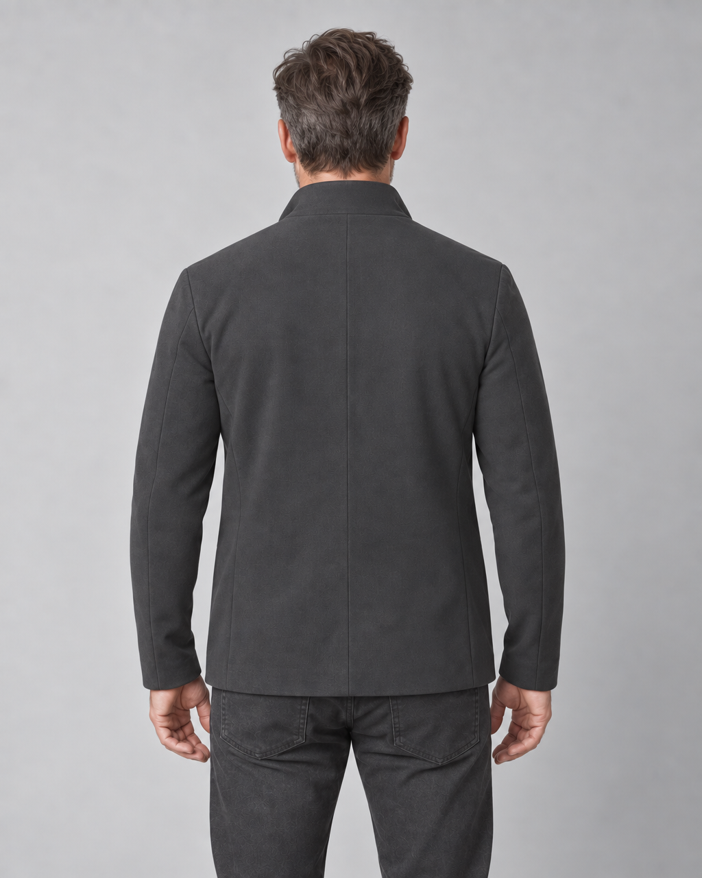 Homme vu de dos portant un blazer gris foncé, cadré de la tête au haut des cuisses