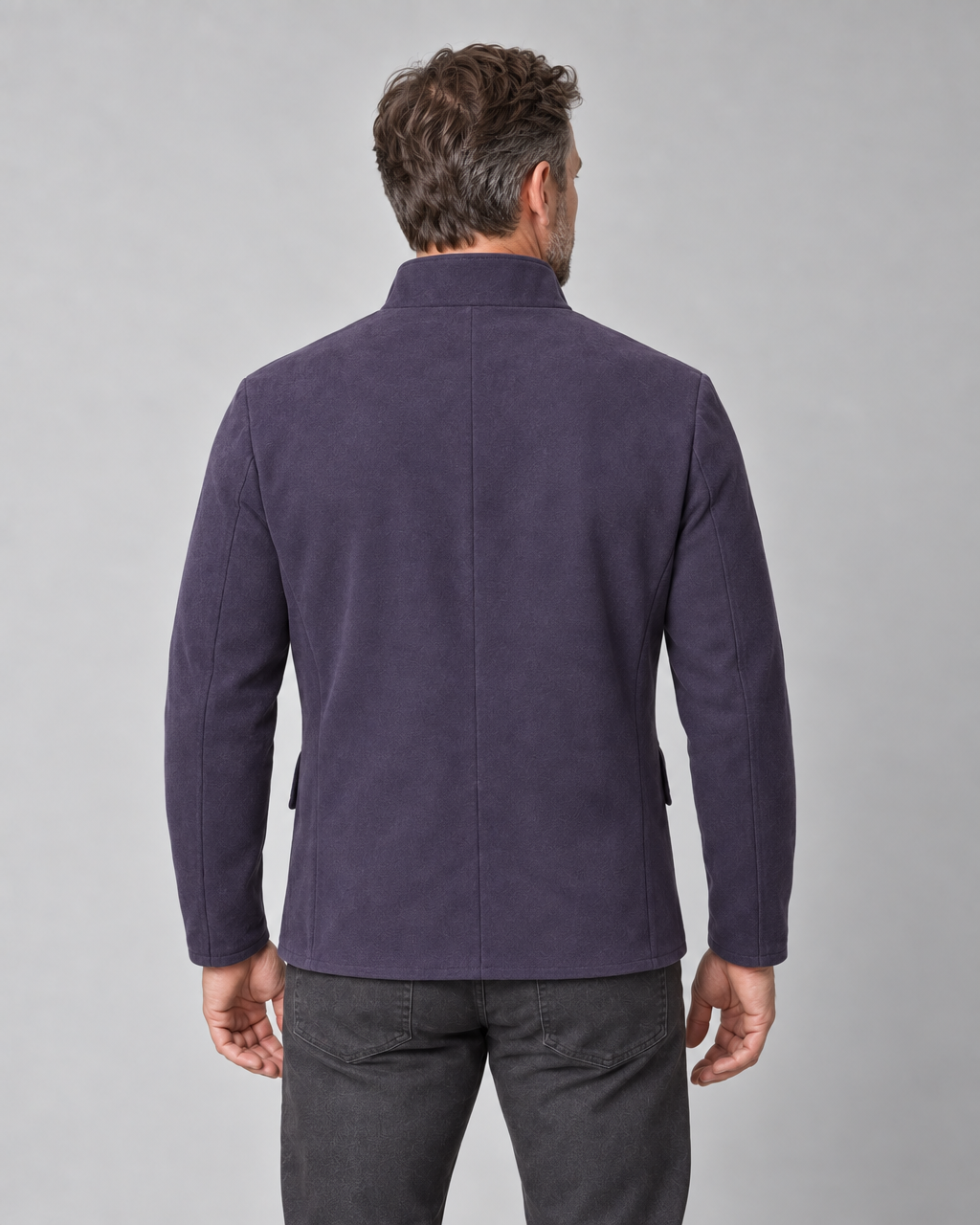 Vue de dos recadrée d’un homme portant une veste violette à col montant.